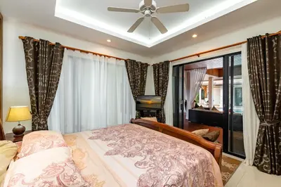 a bedroom with a bed and a ceiling fan at Champagne Villa Luxurious Tropical Pool Villa in Rawai Beach