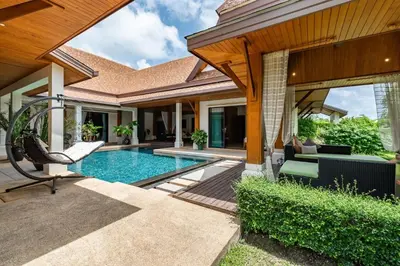 a backyard with a swimming pool and a house at Champagne Villa Luxurious Tropical Pool Villa in Rawai Beach