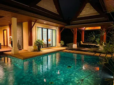 a swimming pool in front of a house at Champagne Villa Luxurious Tropical Pool Villa in Rawai Beach