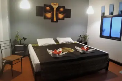 a bedroom with a bed with two plates of food on it at Hi Karon Beach in Karon Beach