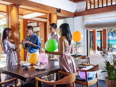 a group of people standing around a table with balloons at Villa Nandana by Elite Havens in Natai Beach