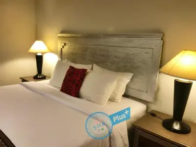 a hotel room with a bed with pillows and two lamps at Le Tanjong House in Patong Beach