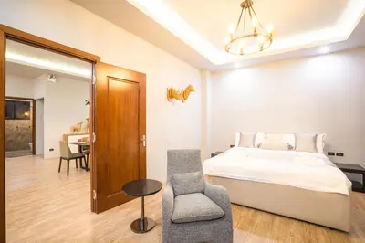 a bedroom with a bed and a chair and a table at Nakara Hill Phuket in Chalong