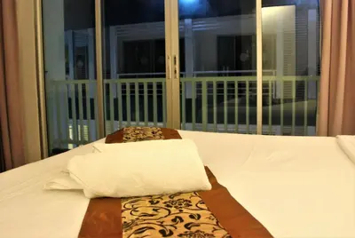 a bed with a towel on it with a window at Freedom Kata in Kata Beach