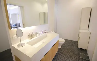 a bathroom with a sink and a mirror and a toilet at Zen Hillside Self Service Apartment in Kamala Beach