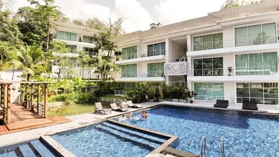 a swimming pool in front of a building at Zen Hillside Self Service Apartment in Kamala Beach