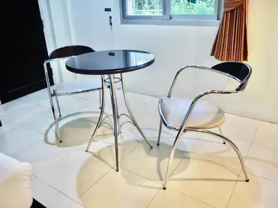 two chairs and a glass table and two chairs at Orm Thong Hotel - SHA Plus in Kathu