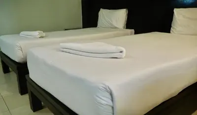 two beds with white towels on top of them at Orm Thong Hotel - SHA Plus in Kathu