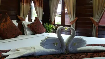 two swans sitting on top of a bed at Baannai Lake View Resort in Ao Nang Beach