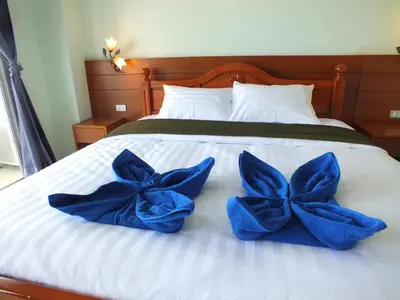 two blue pillows sitting on top of a bed at saithong guesthouse in Rawai Beach