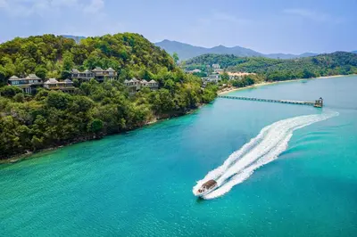 a boat in the water next to a beach at Santhiya Koh Yao Yai Resort & Spa - Compulsory Join Santhiya Speedboat from-to Ao Po Grand Marina at Phuket in Ko Yao Yai