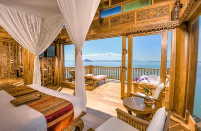 a bedroom with a bed and a balcony with the ocean at Santhiya Koh Yao Yai Resort & Spa - Compulsory Join Santhiya Speedboat from-to Ao Po Grand Marina at Phuket in Ko Yao Yai
