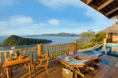 a balcony with a table and chairs and a view of the ocean at Santhiya Koh Yao Yai Resort & Spa - Compulsory Join Santhiya Speedboat from-to Ao Po Grand Marina at Phuket in Ko Yao Yai