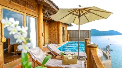 a house with a swimming pool and an umbrella at Santhiya Koh Yao Yai Resort & Spa - Compulsory Join Santhiya Speedboat from-to Ao Po Grand Marina at Phuket in Ko Yao Yai