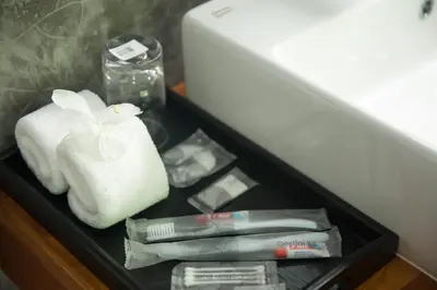 a drawer with a white towel and a pile of items at Purana Resort Koh Yao Noi - SHA Extra plus in Ko Yao Noi