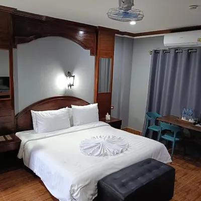 a bedroom with a large bed with a wooden headboard at The Guest House - Apartment in Patong Beach