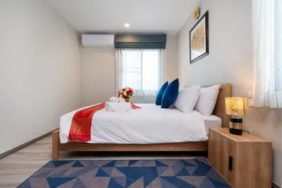 a bedroom with a large white bed and a window at The Title Residencies Naiyang Pool View in Nai Yang Beach