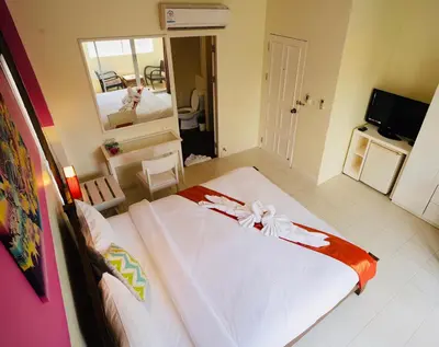 a bedroom with a large bed and a mirror at OK Phuket in Kata Beach