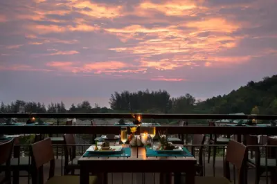 a table with plates of food on top of a balcony at Mandarava Resort and Spa, Karon Beach in Karon Beach
