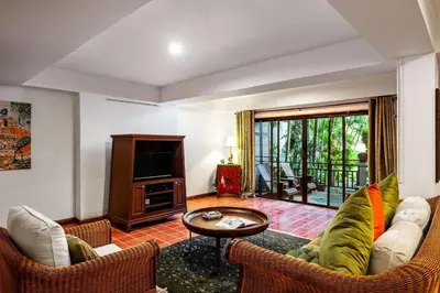 a living room with a couch and a tv at The Sand Beach Apartment in Nai Harn Beach
