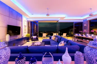 a living room with a blue couch and a tv at Villa Momo Private Pool near Kata Beach in Kata Beach