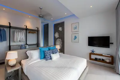 a bedroom with a large white bed with blue pillows at Villa Momo Private Pool near Kata Beach in Kata Beach