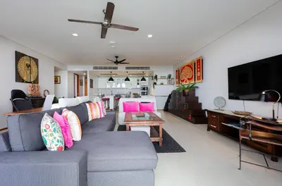 a living room with a gray couch with pink pillows at The heights Kata seaview C1 near Kata Beach in Kata Beach