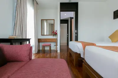 a hotel room with two beds and a desk at Kata Gardens Penthouse sea view 4C near Kata Noi Beach in Kata Beach
