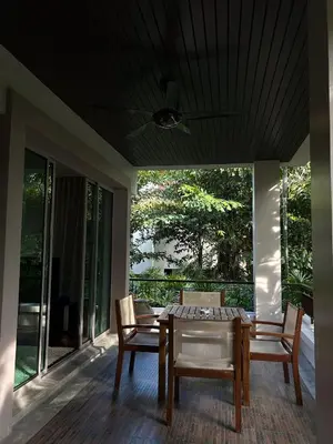a dining room with a table and chairs on a porch at Kata Gardens Luxury Apartment 8B at Kata Noi Beach in Kata Beach