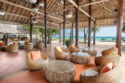an outdoor patio with tables and chairs and the ocean at SAii Phi Phi Island Village in Phi Phi Don