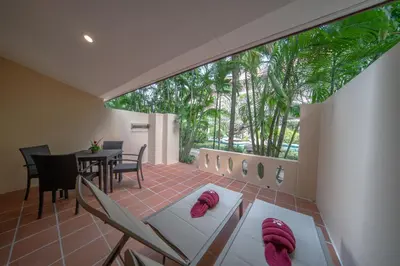 a living room with a table and chairs at Kata Palm Resort - SHA Plus in Kata Beach