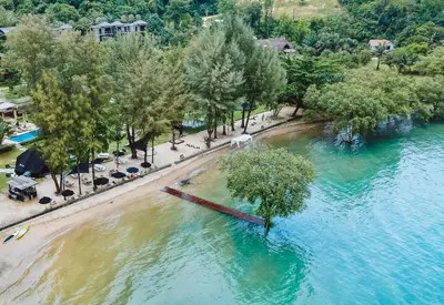 an aerial view of a river with trees and a beach at The Mangrove Phuket by Blu Monkey in Panwa Beach