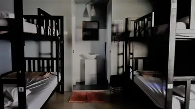 a room with three bunk beds and a sink at Blanco Beach Bar Hostel in Phi Phi Don