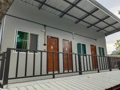 a house with wooden doors and a balcony at Blanco Beach Bar Hostel in Phi Phi Don