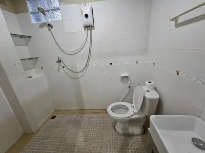 a bathroom with a shower and a toilet and a sink at Baan Malee in Phuket Town