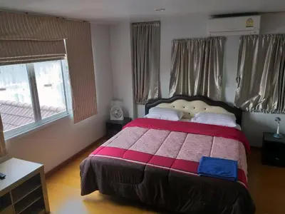a bedroom with a bed with a red and pink blanket at Baan Malee in Phuket Town
