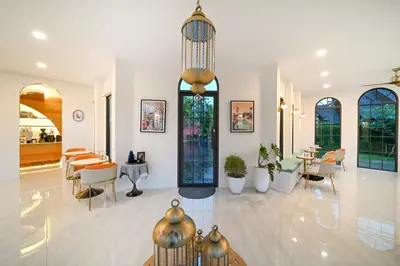a lobby with tables and chairs and a dining room at The Kiri Villas Resort in Thalang