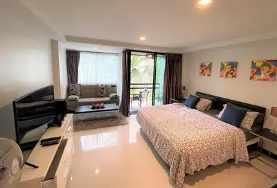 a bedroom with a bed and a couch and a television at Studio at Kris Condo walk to Bangtao beach 2304 in Bang Tao Beach