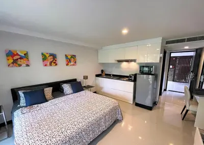 a bedroom with a bed and a kitchen with a refrigerator at Studio at Kris Condo walk to Bangtao beach 2304 in Bang Tao Beach