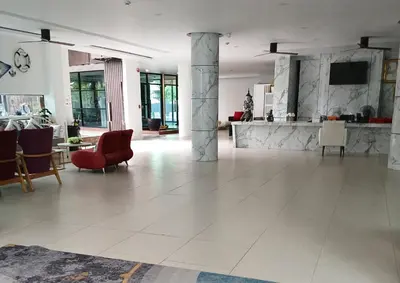 a large living room with a red chair and a table at Studio at Kris Condo walk to Bangtao beach 2304 in Bang Tao Beach