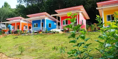 a row of colourful houses in a yard at Koh Yao Candy House in Ko Yao Yai