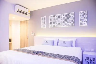 a bedroom with a large white bed with white pillows at Peranakan Boutique Hotel - SHA Plus in Phuket Town