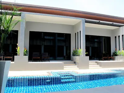 a house with a swimming pool in front of it at Alphabeto Resort in Nai Harn Beach
