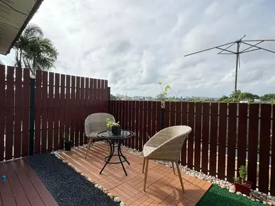 a patio with two chairs and a table on a fence at Canal Resort in Nai Yang Beach