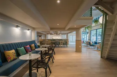 a restaurant with tables and chairs in a room at The Blanket Hotel Phuket Old Town in Phuket Town