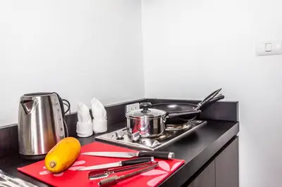 a kitchen counter with a stove with a red cutting board at Wazza's Patong Apartment, Smart TV and Fast Wi-Fi in Patong Beach