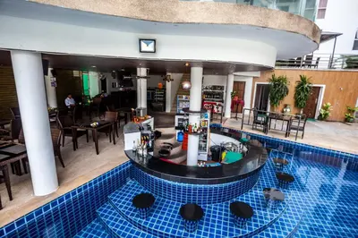 a swimming pool with a bar in a hotel at Wazza's Patong Apartment, Smart TV and Fast Wi-Fi in Patong Beach