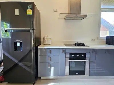 a kitchen with a stainless steel refrigerator and a stove at JJ Queen Villa and Spa Kohyaonoi in Ko Yao Noi