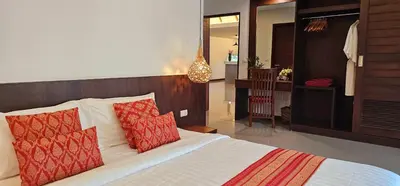 a bedroom with a bed with two red pillows at JJ Queen Villa and Spa Kohyaonoi in Ko Yao Noi