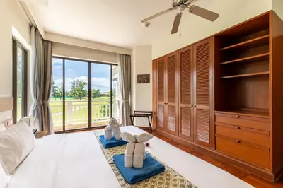 a bedroom with a large bed and a large window at Allamanda Laguna Phuket by RESAVA in Bang Tao Beach